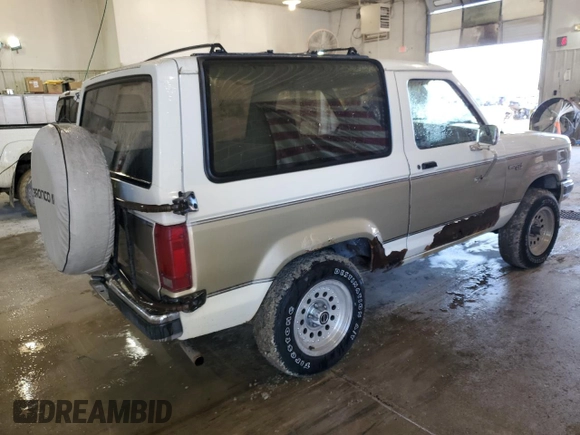 1990 Ford Bronco z VIN 1FMCU14T9LUA62663, wystawiony jako Copart lot #85040114 z przebiegiem 9 963 mil mil oraz Czysty tytuł • Clean title. Historia ofert i sprzedaży dostępna na DreamBid. Obrazek 3.