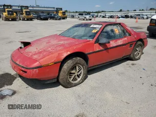 1988 Pontiac Fiero z VIN 1G2PE11R4JP226056, wystawiony jako Copart lot #50711235 z przebiegiem 140 888 mil mil oraz Czysty tytuł • Clean title. Historia ofert i sprzedaży dostępna na DreamBid. Obrazek 1.