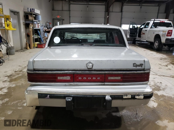 1989 Dodge Dynasty z VIN 1B3BC4634KD442902, wystawiony jako Copart lot #85151394 z przebiegiem 63 120 mil mil oraz Czysty tytuł • Clean title. Historia ofert i sprzedaży dostępna na DreamBid. Obrazek 6.