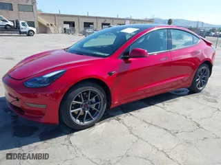 2021 Tesla Model 3 Standard Range Plus with VIN 5YJ3E1EA0MF099562, listed as a IAAI auction lot 41771323 with 26,087 mi miles. Bid and sale history available at carsss.com. Image 2.
