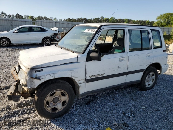 1997 Geo Tracker LSi z VIN 2CNBE1360V6927915, wystawiony jako Copart lot #53469605 z przebiegiem 119 413 mil mil oraz Szkoda całkowita • Salvage title. Historia ofert i sprzedaży dostępna na DreamBid. Obrazek 1.
