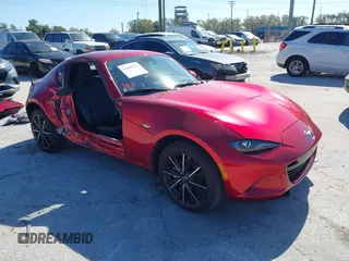 2024 Mazda MX-5 Miata Grand Touring z VIN JM1NDAM72R0601530, wystawiony jako IAAI lot #41683478 z przebiegiem 6 381 mil mil oraz . Historia ofert i sprzedaży dostępna na DreamBid. Obrazek 1.