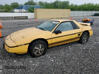 1988 Pontiac Fiero z VIN 1G2PE11R2JP223673, wystawiony jako Copart lot #57300235 z przebiegiem 154 598 mil mil oraz Tytuł czysty. Historia ofert i sprzedaży dostępna na DreamBid. Obrazek 1.