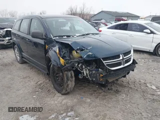 2015 Dodge Journey SE z VIN 3C4PDCABXFT565839, wystawiony jako IAAI lot #41235090 z przebiegiem 174 791 mil mil oraz . Historia ofert i sprzedaży dostępna na DreamBid. Obrazek 1.