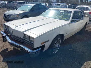 1985 Oldsmobile Toronado Custom Brougham z VIN 1G3EZ57YXFE315260, wystawiony jako IAAI lot #42051171 z przebiegiem Nie podano mil oraz . Historia ofert i sprzedaży dostępna na DreamBid. Obrazek 2.
