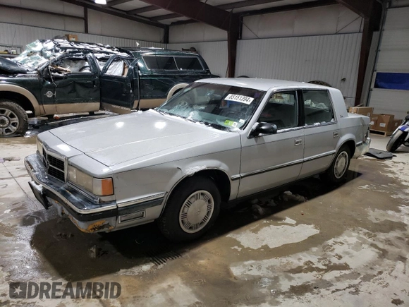 1989 Dodge Dynasty z VIN 1B3BC4634KD442902, wystawiony jako Copart lot #85151394 z przebiegiem 63 120 mil mil oraz Czysty tytuł • Clean title. Historia ofert i sprzedaży dostępna na DreamBid. Obrazek 1.