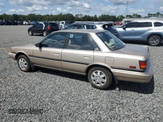 1991 Toyota Camry DLX z VIN 4T1SV21E5MU415356, wystawiony jako Copart lot #74465914 z przebiegiem 74 592 mil mil oraz Szkoda całkowita • Salvage title. Historia ofert i sprzedaży dostępna na DreamBid. Obrazek 2.