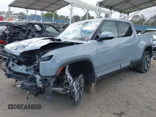 2023 Rivian R1T Adventure z VIN 7FCTGBAA9PN027894, wystawiony jako IAAI lot #42061339 z przebiegiem 5047 mil mil oraz . Historia ofert i sprzedaży dostępna na DreamBid. Obrazek 2.