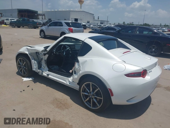 2021 Mazda MX-5 Miata Grand Touring z VIN JM1NDAM71M0457011, wystawiony jako IAAI lot #42427652 z przebiegiem 4 045 mil mil oraz . Historia ofert i sprzedaży dostępna na DreamBid. Obrazek 3.