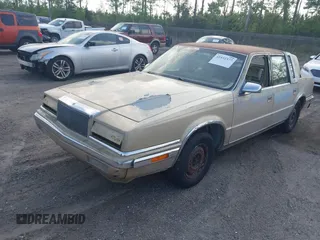 1991 Chrysler New Yorker z VIN 1C3XY66R1MD290736, wystawiony jako IAAI lot #41932377 z przebiegiem 176 868 mil mil oraz . Historia ofert i sprzedaży dostępna na DreamBid. Obrazek 2.