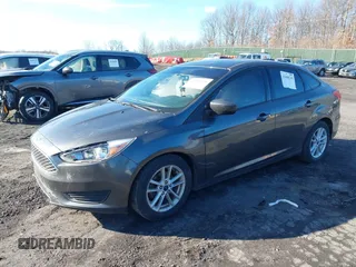 2018 Ford Focus SE z VIN 1FADP3F2XJL295508, wystawiony jako IAAI lot #41608216 z przebiegiem 89 696 mil mil oraz . Historia ofert i sprzedaży dostępna na DreamBid. Obrazek 2.
