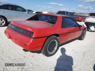 1988 Pontiac Fiero z VIN 1G2PE11R1JP219470, wystawiony jako Copart lot #77772864 z przebiegiem 94 011 mil mil oraz Szkody całkowita. Historia ofert i sprzedaży dostępna na DreamBid. Obrazek 3.