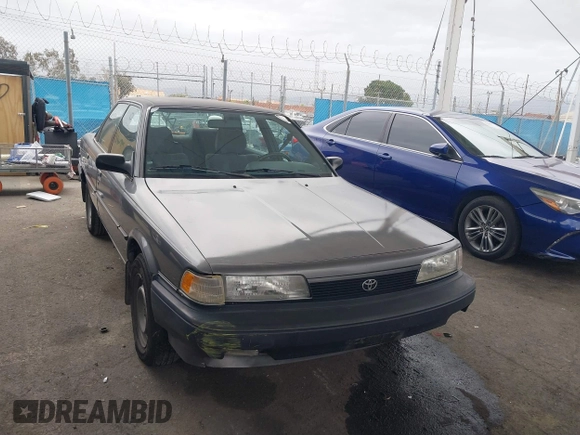 1990 Toyota Camry DLX z VIN 4T1SV21E7LU248206, wystawiony jako IAAI lot #41793635 z przebiegiem 83 550 mil mil oraz . Historia ofert i sprzedaży dostępna na DreamBid. Obrazek 1.