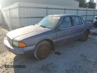 1992 Plymouth Acclaim z VIN 1P3XA46K8NF255561, wystawiony jako Copart lot #74290964 z przebiegiem 126 154 mil mil oraz Szkody całkowita. Historia ofert i sprzedaży dostępna na DreamBid. Obrazek 1.