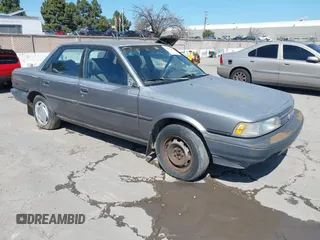 1990 Toyota Camry DLX z VIN 4T1SV21E6LU257382, wystawiony jako IAAI lot #41848382 z przebiegiem 322 005 mil mil oraz . Historia ofert i sprzedaży dostępna na DreamBid. Obrazek 1.