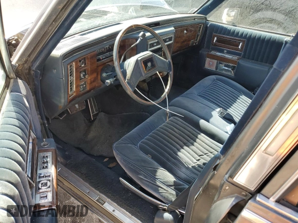 1988 Cadillac Brougham z VIN 1G6DW51Y2J9714052, wystawiony jako Copart lot #77274064 z przebiegiem 69 106 mil mil oraz Szkoda całkowita • Salvage title. Historia ofert i sprzedaży dostępna na DreamBid. Obrazek 8.
