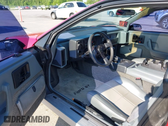 1986 Pontiac Fiero z VIN 1G2PG9791GP267415, wystawiony jako IAAI lot #42461769 z przebiegiem Nie podano mil oraz . Historia ofert i sprzedaży dostępna na DreamBid. Obrazek 8.