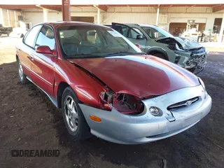1999 Ford Taurus SE Comfort z VIN 1FAFP53SXXG325858, wystawiony jako IAAI lot #41633884 z przebiegiem 171 210 mil mil oraz . Historia ofert i sprzedaży dostępna na DreamBid. Obrazek 1.