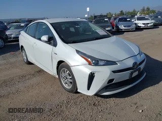 2021 Toyota Prius L Eco z VIN JTDKAMFU5M3142159, wystawiony jako IAAI lot #42396012 z przebiegiem 265 878 mil mil oraz . Historia ofert i sprzedaży dostępna na DreamBid. Obrazek 1.