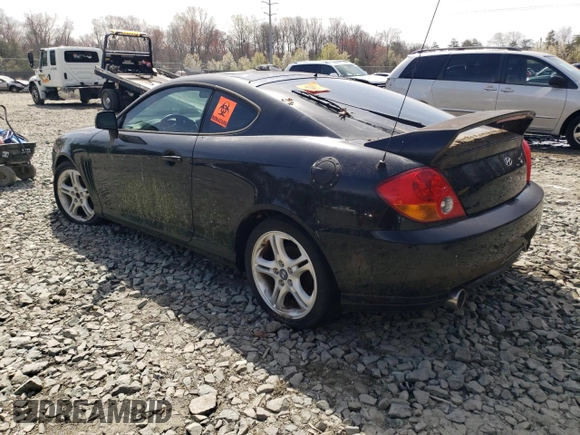 2003 Hyundai Tiburon GT z VIN KMHHN65F13U084620, wystawiony jako Copart lot #46880185 z przebiegiem Nie podano mil oraz Nie do naprawy • Non repairable. Historia ofert i sprzedaży dostępna na DreamBid. Obrazek 2.