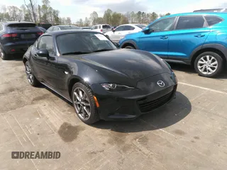 2021 Mazda MX-5 Miata Grand Touring z VIN JM1NDAM75M0451597, wystawiony jako IAAI lot #41932712 z przebiegiem 61 710 mil mil oraz . Historia ofert i sprzedaży dostępna na DreamBid. Obrazek 1.