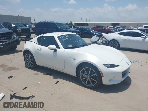 2021 Mazda MX-5 Miata Grand Touring z VIN JM1NDAM71M0457011, wystawiony jako IAAI lot #42427652 z przebiegiem 4 045 mil mil oraz . Historia ofert i sprzedaży dostępna na DreamBid. Obrazek 1.