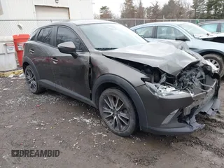 2018 Mazda CX-3 Touring z VIN JM1DKFC70J0320122, wystawiony jako IAAI lot #41718852 z przebiegiem 144 357 mil mil oraz . Historia ofert i sprzedaży dostępna na DreamBid. Obrazek 1.