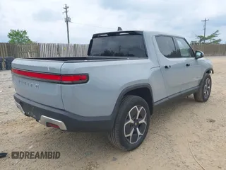2023 Rivian R1T Adventure z VIN 7FCTGBAA6PN028520, wystawiony jako IAAI lot #42117498 z przebiegiem 24 583 mil mil oraz . Historia ofert i sprzedaży dostępna na DreamBid. Obrazek 4.