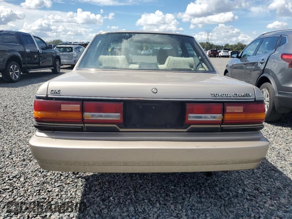 1991 Toyota Camry DLX z VIN 4T1SV21E5MU415356, wystawiony jako Copart lot #74465914 z przebiegiem 74 592 mil mil oraz Szkoda całkowita • Salvage title. Historia ofert i sprzedaży dostępna na DreamBid. Obrazek 6.