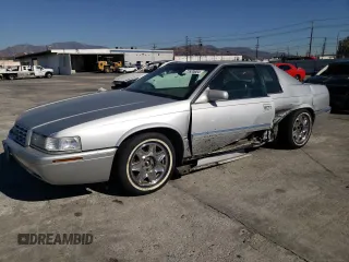 1999 Cadillac Eldorado z VIN 1G6EL12Y0XU604529, wystawiony jako Copart lot #77620004 z przebiegiem 246 032 mil mil oraz Szkoda całkowita • Salvage title. Historia ofert i sprzedaży dostępna na DreamBid. Obrazek 1.