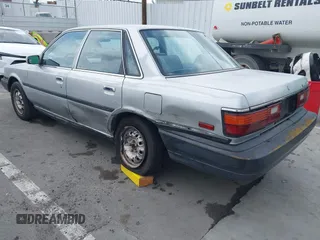 1990 Toyota Camry z VIN 4T1SV24E0LU190211, wystawiony jako IAAI lot #42368986 z przebiegiem 145 167 mil mil oraz . Historia ofert i sprzedaży dostępna na DreamBid. Obrazek 3.