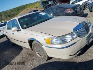 1999 Lincoln Town Car Cartier z VIN 1LNHM83W4XY714100, wystawiony jako IAAI lot #41764003 z przebiegiem Nie podano mil oraz . Historia ofert i sprzedaży dostępna na DreamBid. Obrazek 1.
