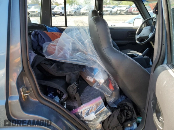 1999 Jeep Cherokee Sport with VIN 1J4FT68S1XL577603, listed as a Copart auction lot 54216115 with 180,128 mi miles and Salvage title. Bid and sale history available at DreamBid. Image 11.