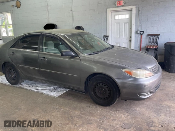 2002 Toyota Camry LE z VIN 4T1BE30K52U542523, wystawiony jako Copart lot #57983805 z przebiegiem 264 137 mil mil oraz Czysty tytuł • Clean title. Historia ofert i sprzedaży dostępna na DreamBid. Obrazek 1.