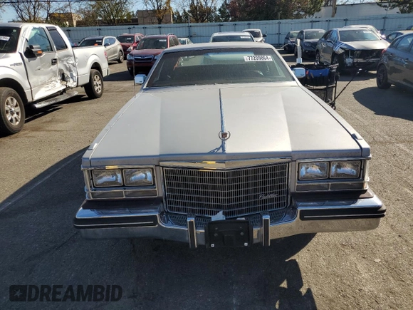 1984 Cadillac Seville z VIN 1G6AS6984EE826325, wystawiony jako Copart lot #77209864 z przebiegiem 26 366 mil mil oraz Czysty tytuł • Clean title. Historia ofert i sprzedaży dostępna na DreamBid. Obrazek 5.