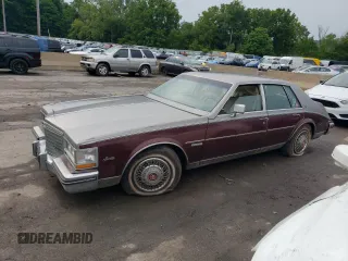 1983 Cadillac Seville z VIN 1G6AS6983DE800569, wystawiony jako Copart lot #62057784 z przebiegiem 50 322 mil mil oraz Tytuł czysty. Historia ofert i sprzedaży dostępna na DreamBid. Obrazek 1.
