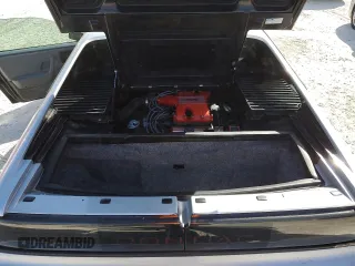 1986 Pontiac Fiero z VIN 1G2PG9799GP261135, wystawiony jako Copart lot #77305934 z przebiegiem 53 837 mil mil oraz Szkody całkowita. Historia ofert i sprzedaży dostępna na DreamBid. Obrazek 11.
