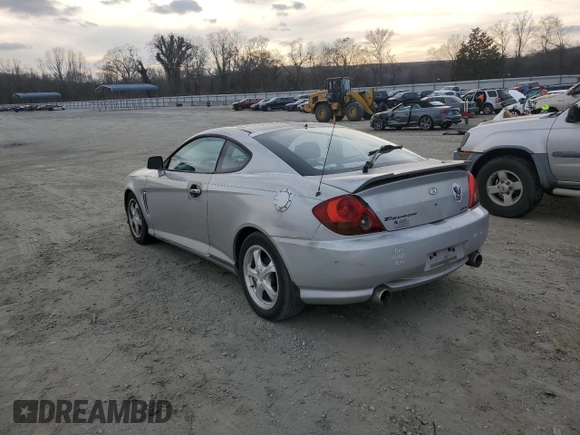 2003 Hyundai Tiburon GT z VIN KMHHN65F63U064962, wystawiony jako Copart lot #44804045 z przebiegiem 186 171 mil mil oraz Szkoda całkowita • Salvage title. Historia ofert i sprzedaży dostępna na DreamBid. Obrazek 2.