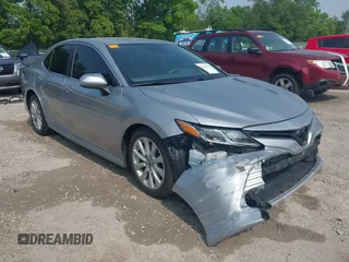2019 Toyota Camry LE z VIN 4T1B11HK5KU839134, wystawiony jako IAAI lot #42410529 z przebiegiem 98 783 mil mil oraz . Historia ofert i sprzedaży dostępna na DreamBid. Obrazek 1.