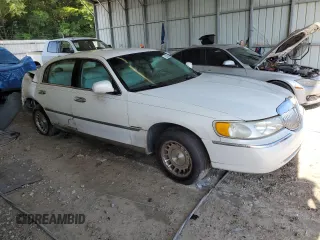 1999 Lincoln Town Car Executive with VIN 1LNHM81W2XY658371, listed as a Copart auction lot 60249045 with 191,266 mi miles and Salvage title. Bid and sale history available at DreamBid. Image 4.