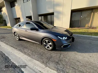 2020 Honda Civic LX z VIN 19XFC2F64LE210282, wystawiony jako Copart lot #60940945 z przebiegiem 55 172 mil mil oraz Czysty tytuł • Clean title. Historia ofert i sprzedaży dostępna na DreamBid. Obrazek 1.