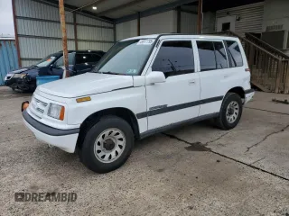 1996 Suzuki Sidekick JX z VIN 2S3TD03V7T6409487, wystawiony jako Copart lot #49977795 z przebiegiem 137 011 mil mil oraz Szkoda całkowita • Salvage title. Historia ofert i sprzedaży dostępna na DreamBid. Obrazek 1.