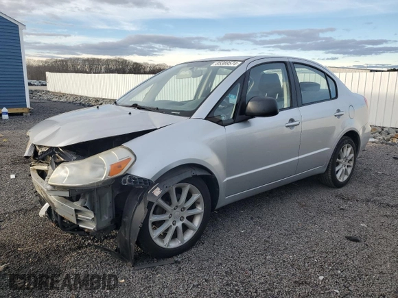 2011 Suzuki SX4 LE z VIN JS2YC5A23B6300189, wystawiony jako Copart lot #85389574 z przebiegiem 71 272 mil mil oraz Czysty tytuł • Clean title. Historia ofert i sprzedaży dostępna na DreamBid. Obrazek 1.