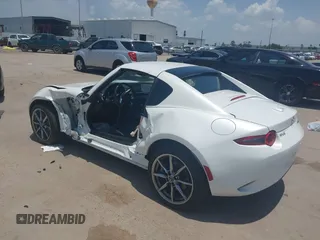 2021 Mazda MX-5 Miata Grand Touring z VIN JM1NDAM71M0457011, wystawiony jako IAAI lot #42427652 z przebiegiem 4 045 mil mil oraz . Historia ofert i sprzedaży dostępna na DreamBid. Obrazek 3.
