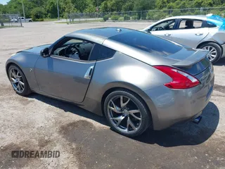 2013 Nissan 370Z Touring z VIN JN1AZ4EH2DM384011, wystawiony jako IAAI lot #42274166 z przebiegiem 87 499 mil mil oraz . Historia ofert i sprzedaży dostępna na DreamBid. Obrazek 3.