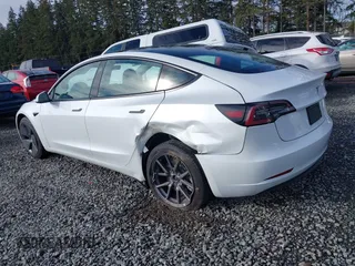 2021 Tesla Model 3 Standard Range Plus z VIN 5YJ3E1EAXMF871730, wystawiony jako IAAI lot #41794274 z przebiegiem 18 791 mil mil oraz . Historia ofert i sprzedaży dostępna na DreamBid. Obrazek 3.