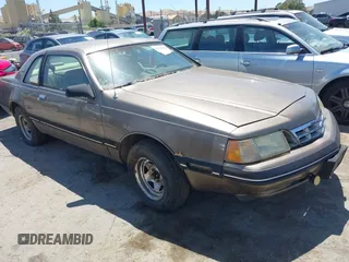 1987 Ford Thunderbird z VIN 1FABP6033HH213366, wystawiony jako IAAI lot #42368900 z przebiegiem Nie podano mil oraz . Historia ofert i sprzedaży dostępna na DreamBid. Obrazek 1.