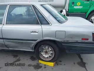 1990 Toyota Camry z VIN 4T1SV24E0LU190211, wystawiony jako IAAI lot #42368986 z przebiegiem 145 167 mil mil oraz . Historia ofert i sprzedaży dostępna na DreamBid. Obrazek 6.