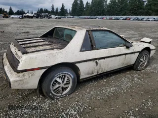 1984 Pontiac Fiero z VIN 1G2AF37R6EP320306, wystawiony jako Copart lot #68255394 z przebiegiem 49 284 mil mil oraz Tytuł czysty. Historia ofert i sprzedaży dostępna na DreamBid. Obrazek 3.