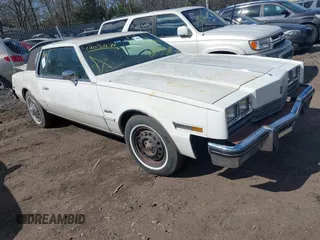 1985 Oldsmobile Toronado Custom Brougham z VIN 1G3EZ57YXFE315260, wystawiony jako IAAI lot #42051171 z przebiegiem Nie podano mil oraz . Historia ofert i sprzedaży dostępna na DreamBid. Obrazek 1.